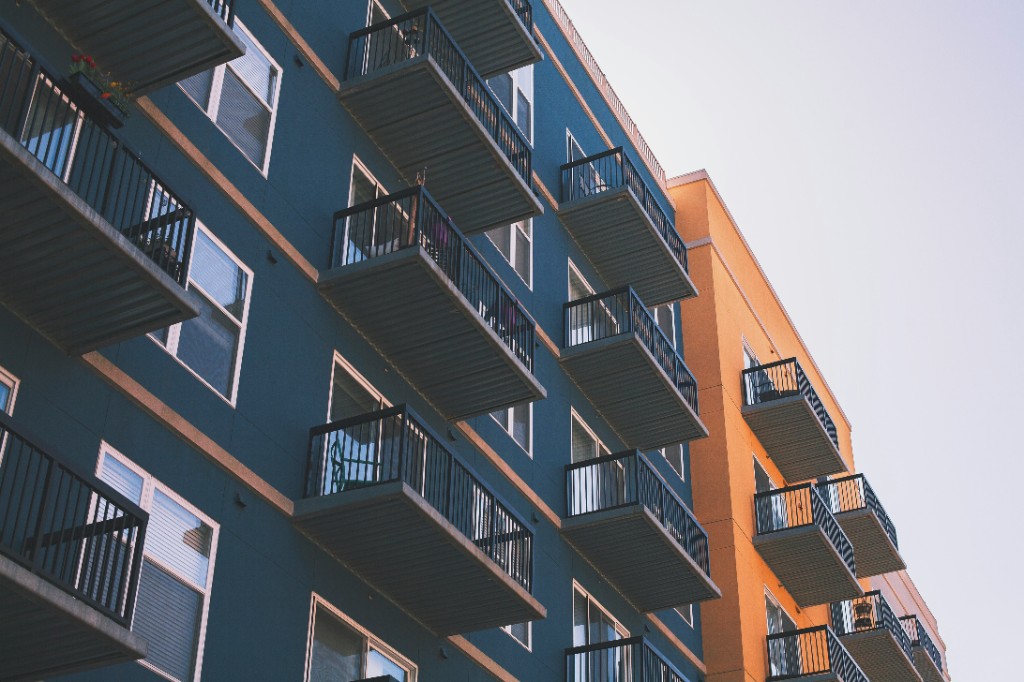 Multi-story apartment building with stacked balconies in blue and orange