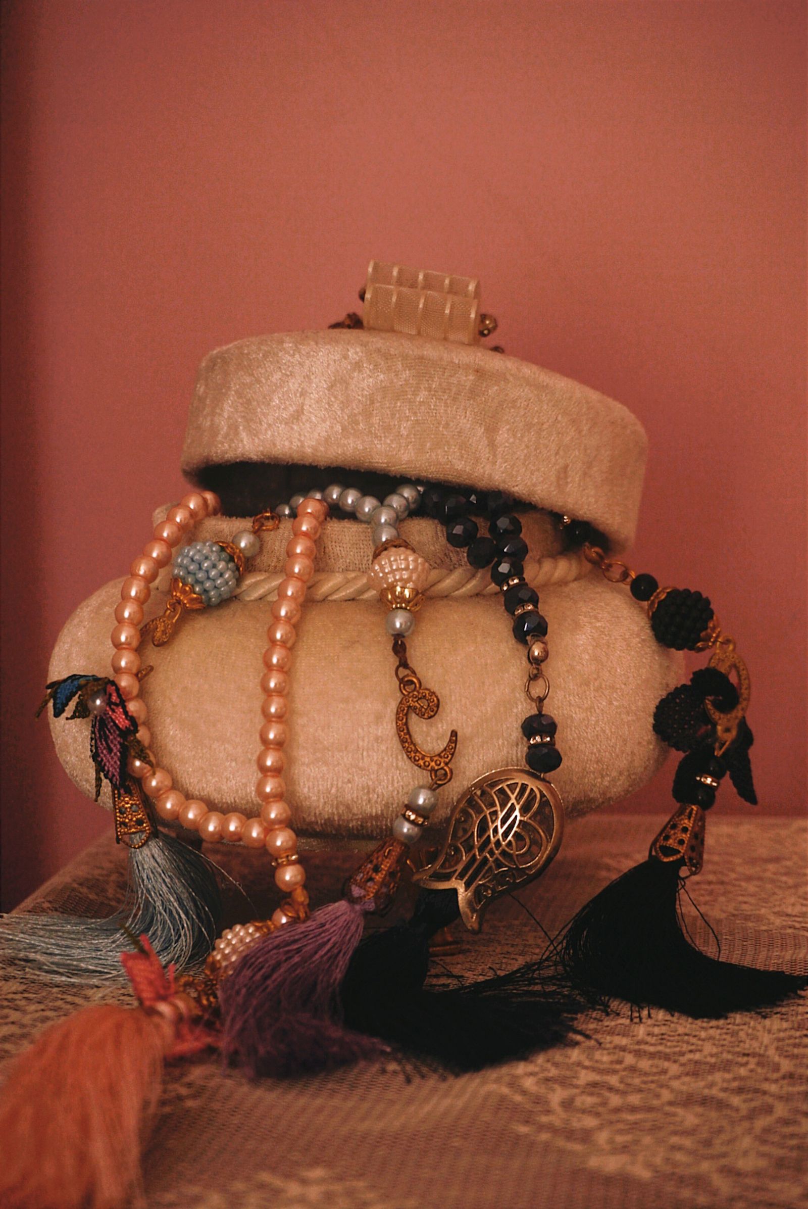 Necklaces draped over a beige jewelry box