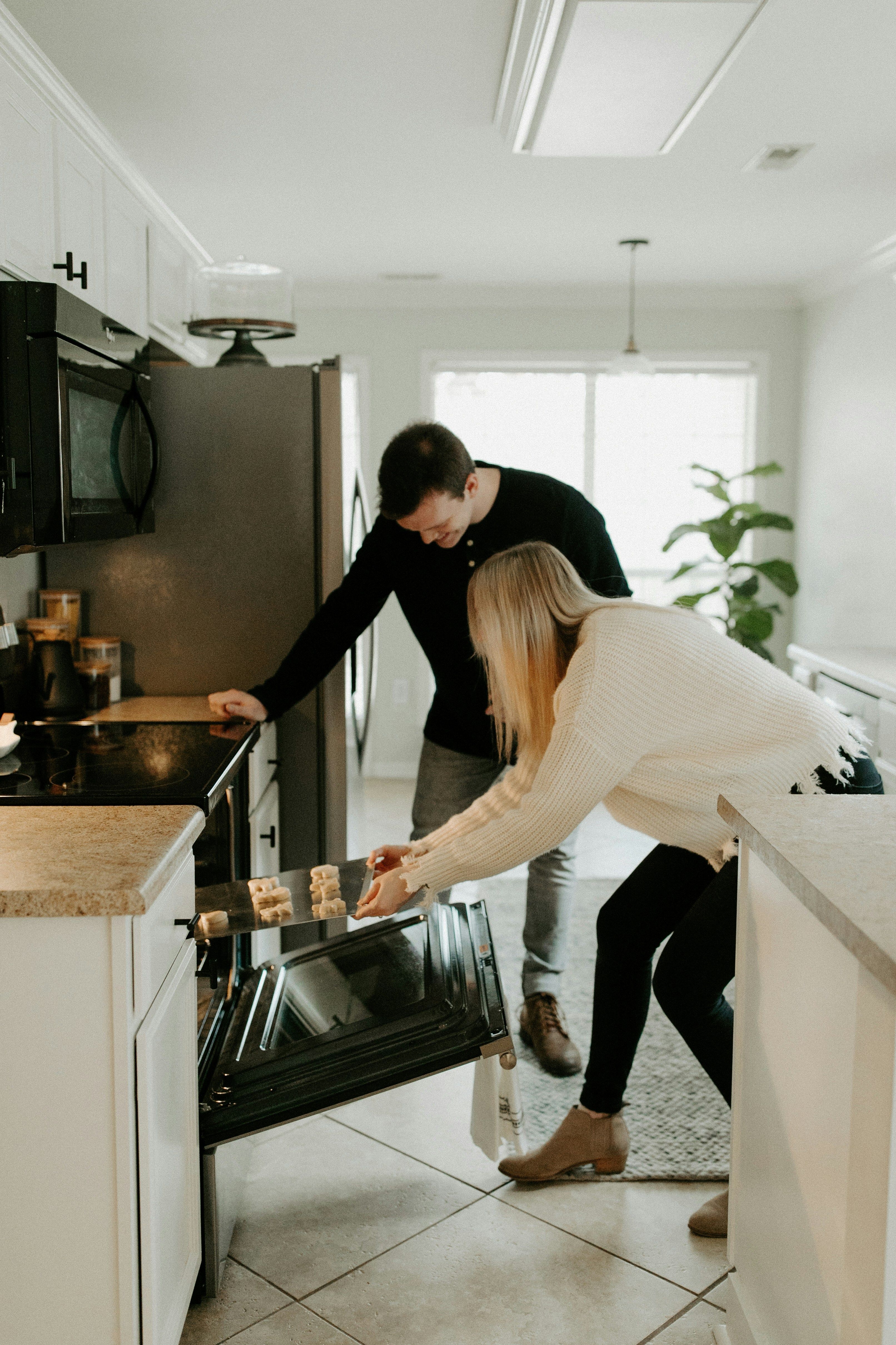 Two people cooking at a stove in a home kitchen