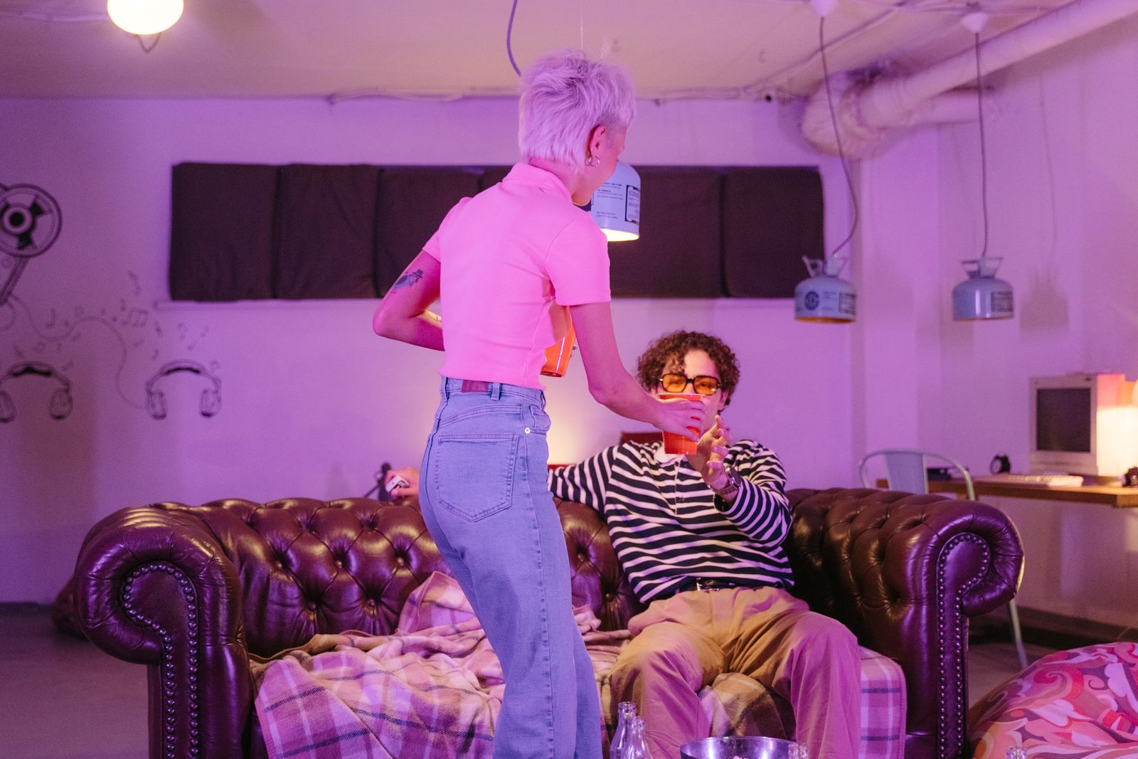 Two friends with drinks in a loft living room